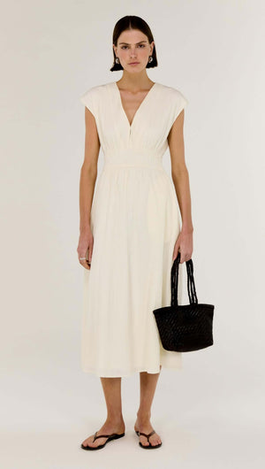 Cream Cotton V-Neck Midi Dress featuring soft cap sleeves and a cinched waist, styled with a black bag.