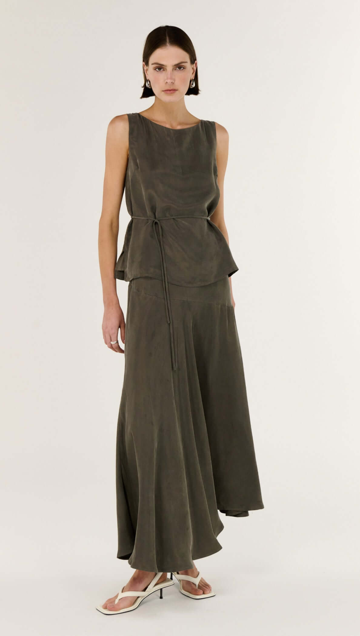 Model wearing the Olive Cupro Asymmetrical Hem Maxi Skirt, showcasing its luxurious movement and elegant silhouette.