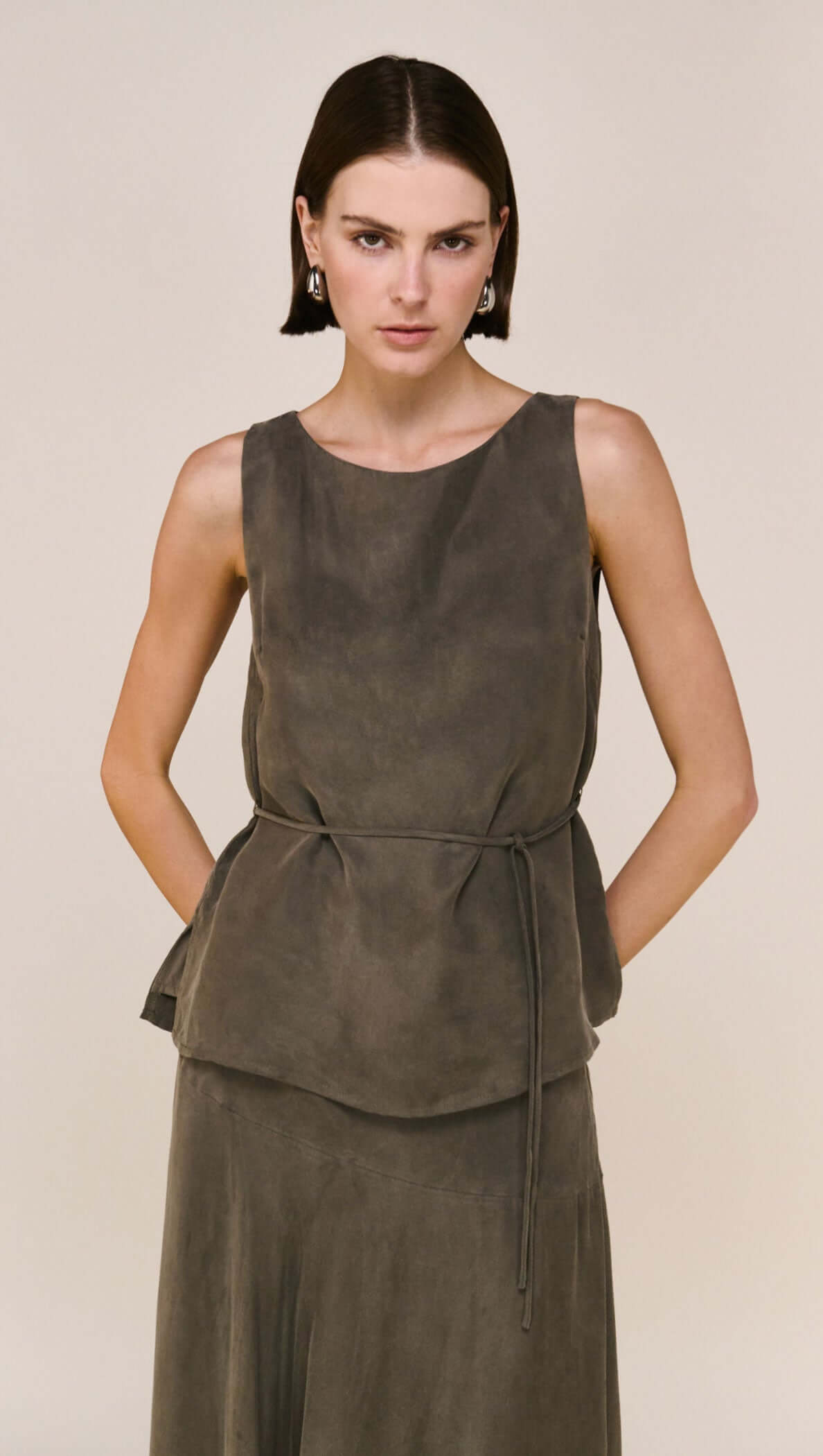 Olive Cupro Waist Tie Tank on a model, showcasing a soft silken finish and adjustable tie for a flattering fit.