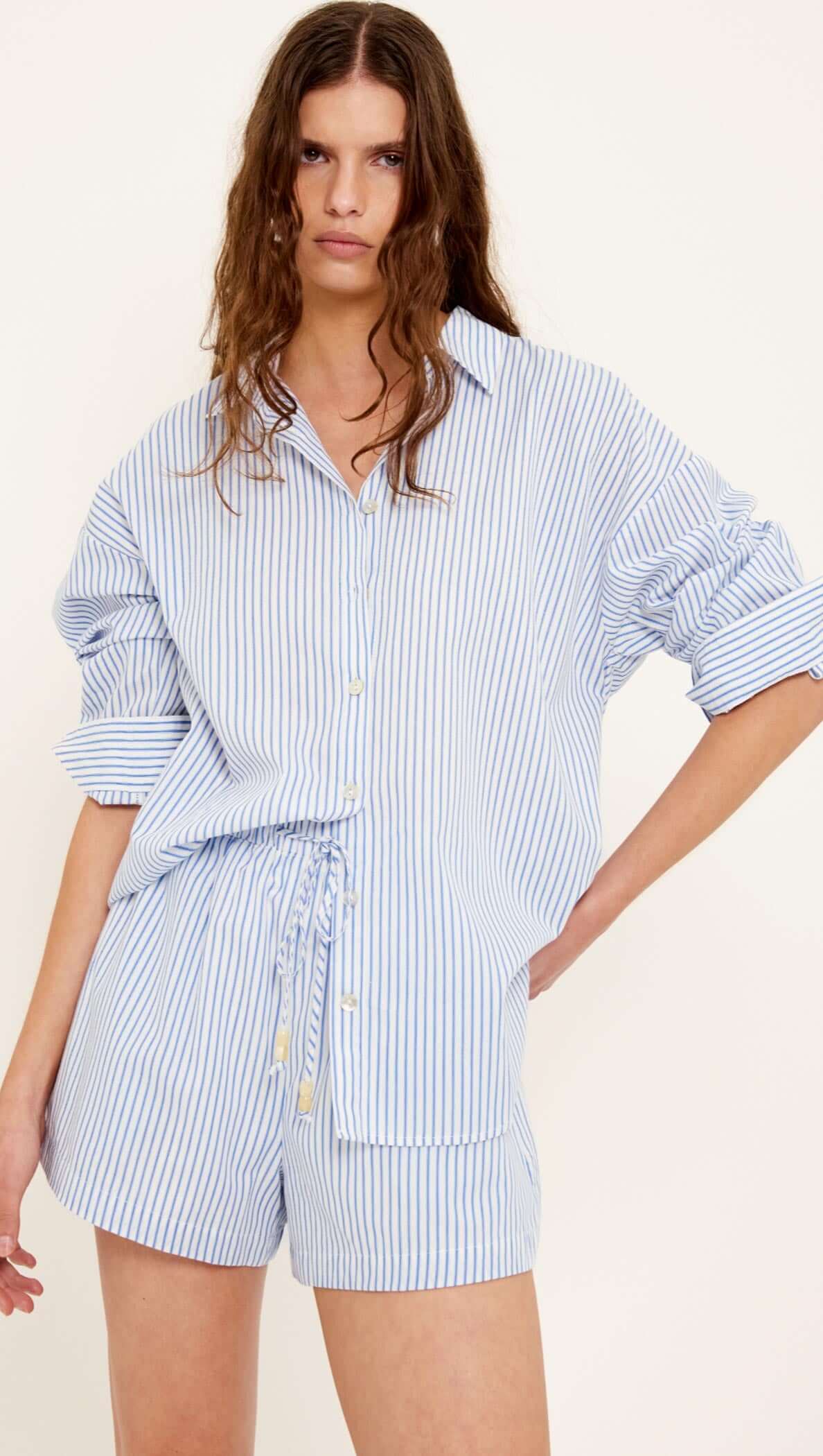 Model wearing Cotton Blue & White Drawstring Shorts paired with a matching oversized shirt, showcasing a relaxed summer style.