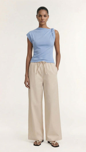 Model wearing a blue top and Stone Cotton Wide Leg Drawstring Pant in a bright, simple studio background.
