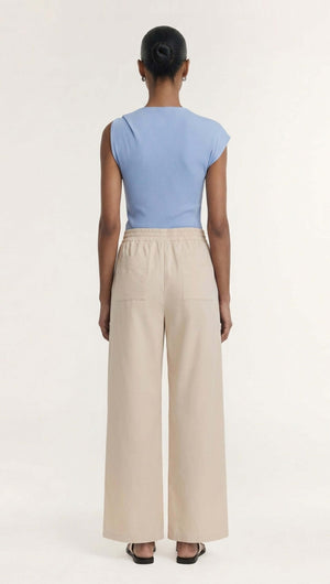 Back view of a model wearing the Stone Cotton Wide Leg Drawstring Pant paired with a blue top.