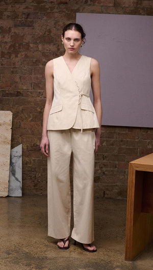 Model showcases the Stone Cotton Wrap Front Vest paired with wide-leg trousers in a chic, minimalistic style.