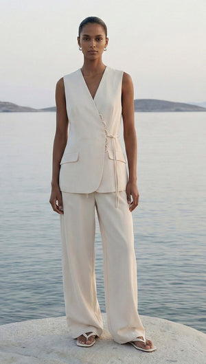 Model wearing the Stone Cotton Wrap Front Vest against a serene backdrop, showcasing its stylish wrap-front design and flap pockets.