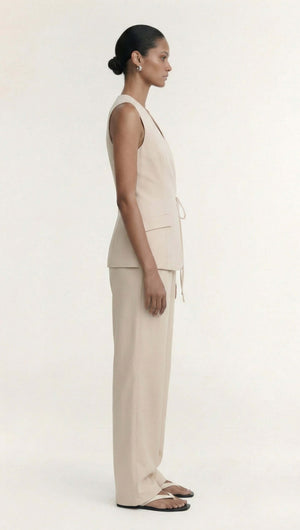 Model wearing the Stone Cotton Wrap Front Vest in a soft ecru hue with tailored design details.
