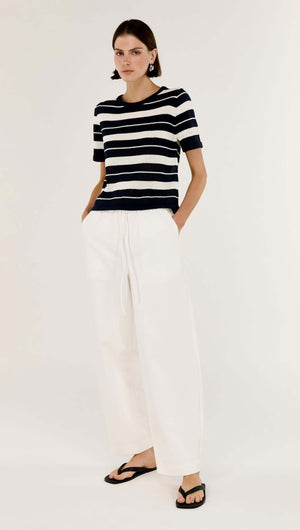Model wearing Striped Crew Neck Knit Tee with classic stripe pattern and white trousers.