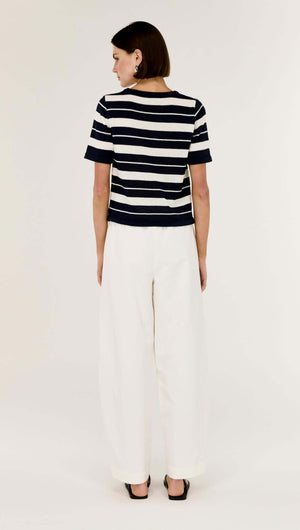 Model wearing a Striped Crew Neck Knit Tee with a classic stripe design and lightweight feel, paired with wide-leg pants.