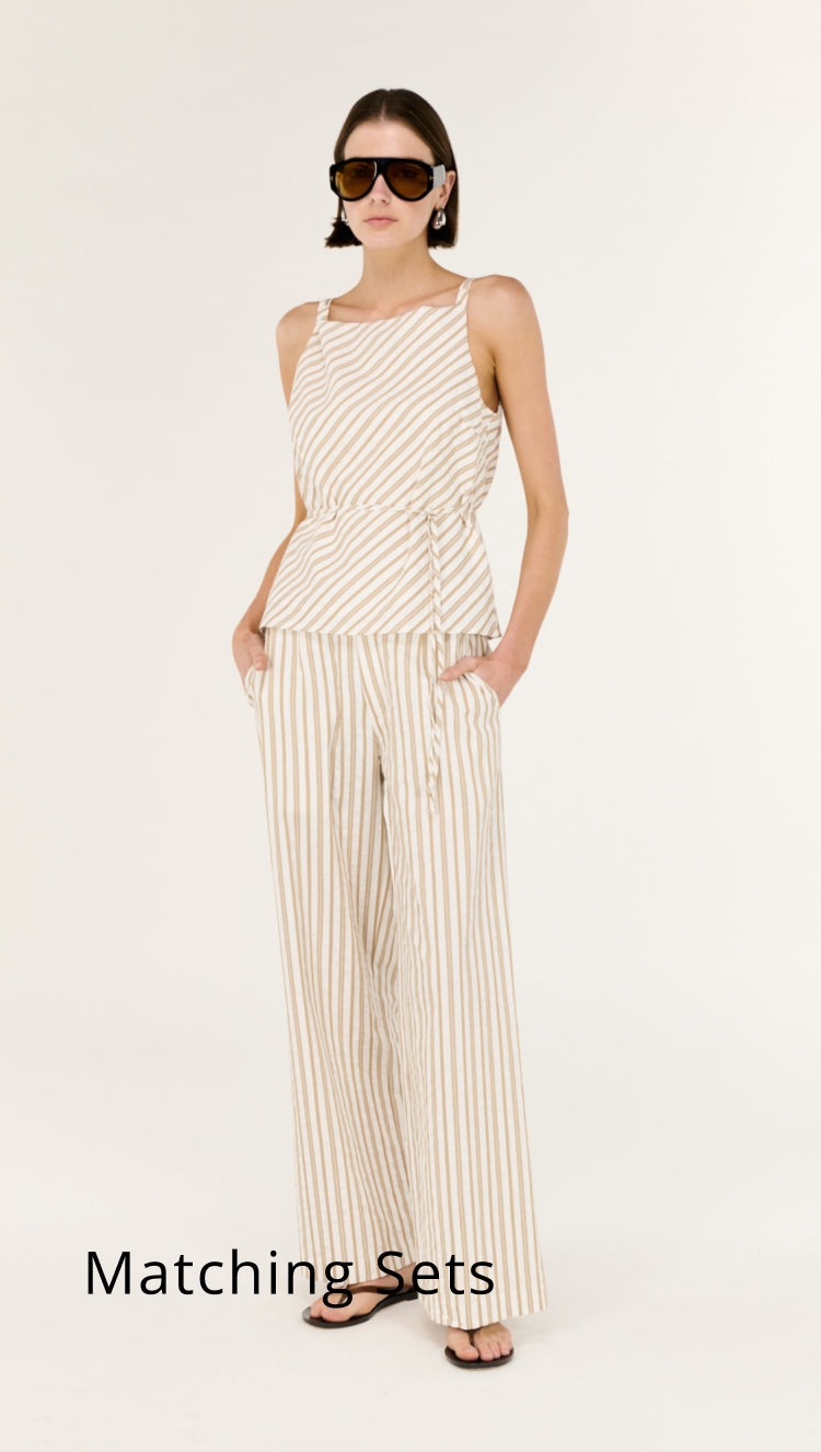 Woman wearing a matching set of top and pants on a white background