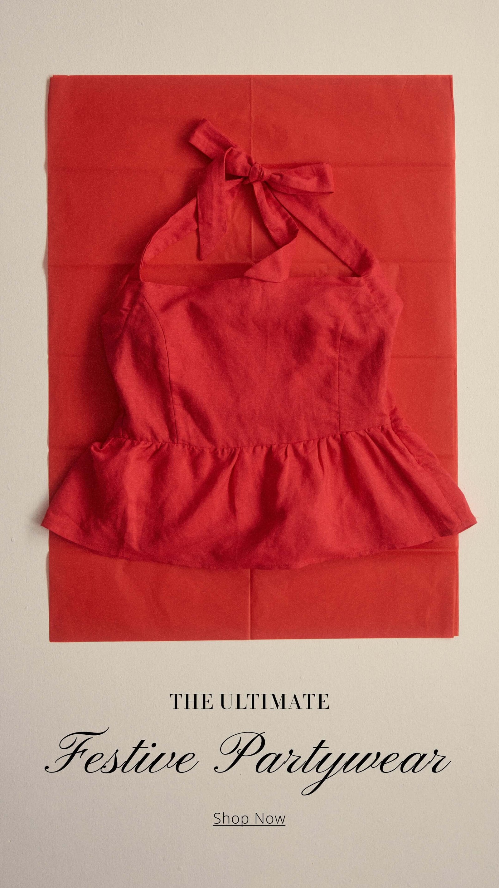 Red halter top on vibrant red background, perfect for festive partywear. Shop the ultimate collection now!