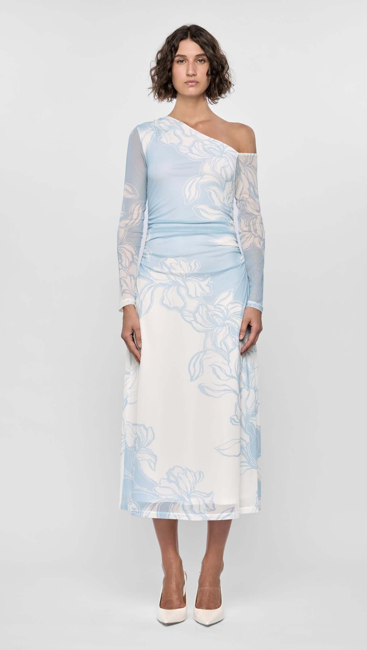 Woman wearing the Aurora Mesh Midi Dress in sky blue floral mesh, featuring a one-shoulder neckline and flared hem.