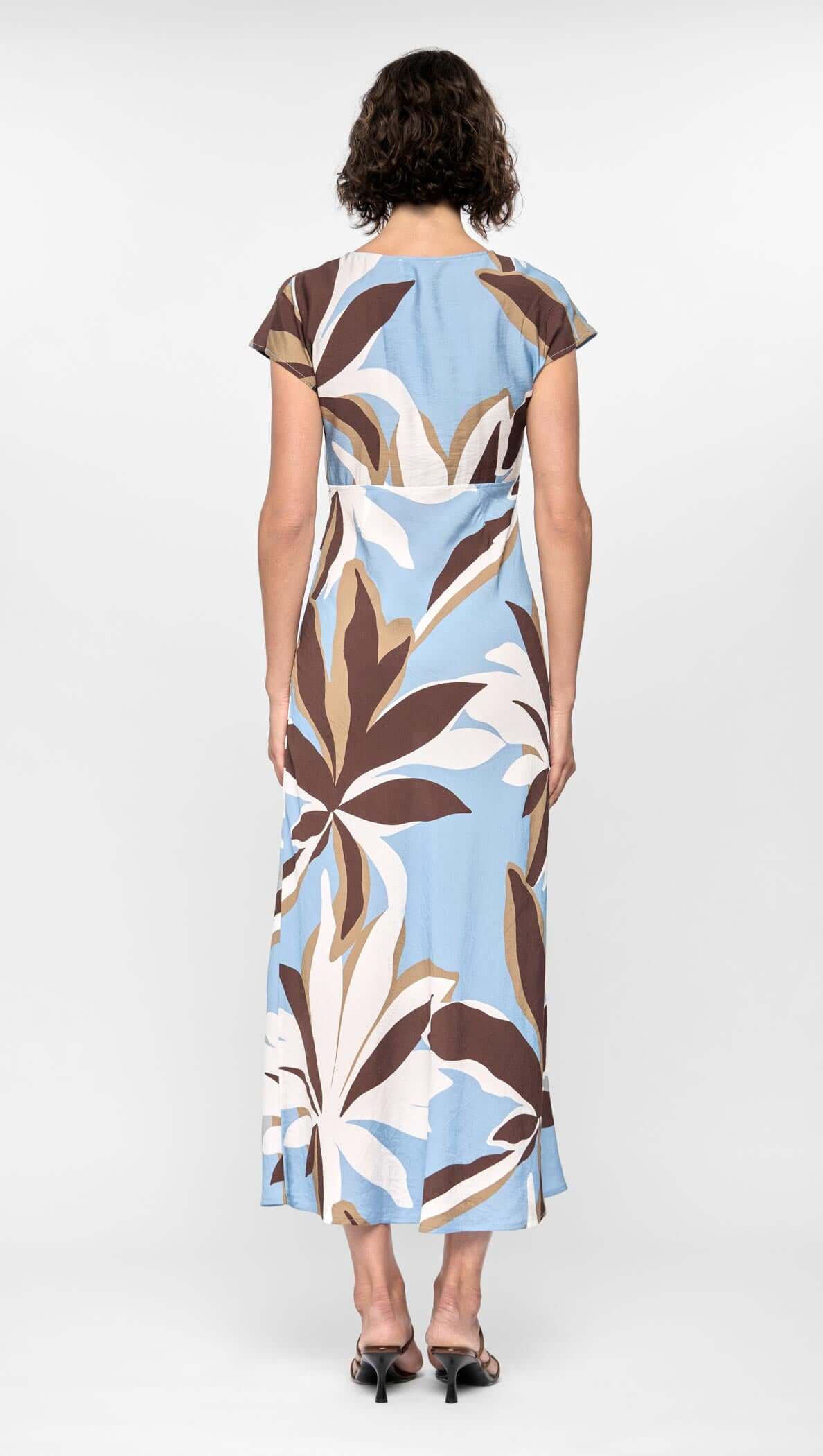 Back view of a Maeve Midi Dress featuring brown, cream and blue abstract floral print, cap sleeves and midi length.