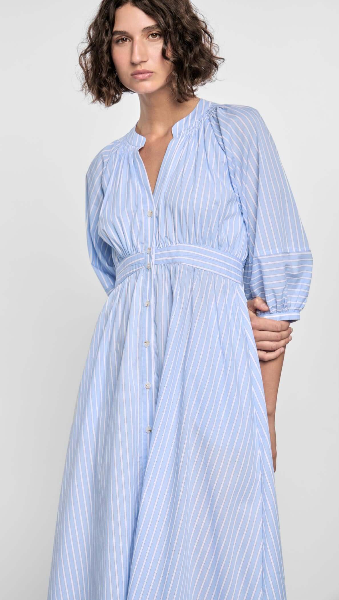 Myra Midi Dress featuring soft blue pinstripes, puff sleeves, empire waist, and button-down front.