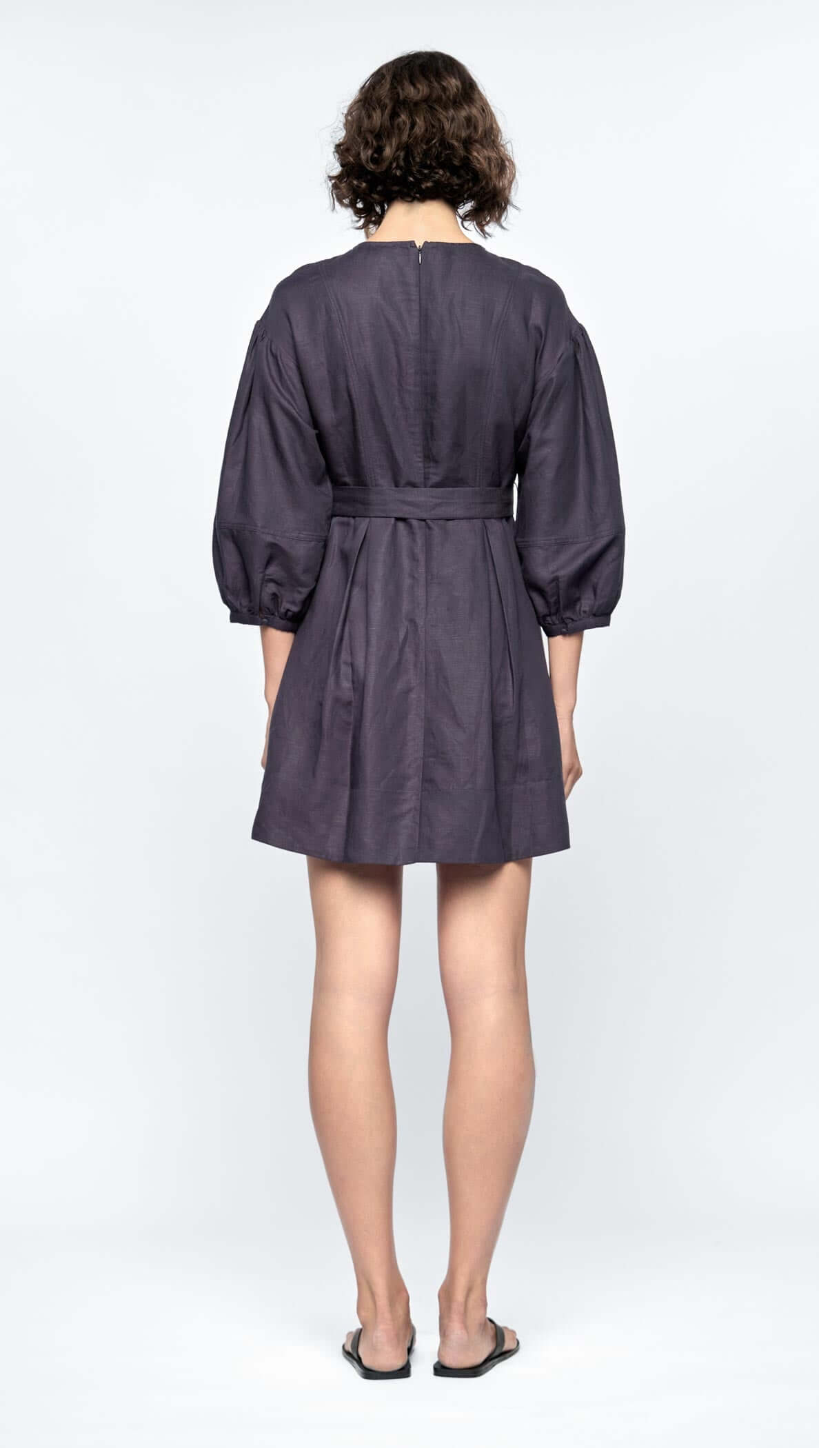 Back view of the Rhea Mini Dress, featuring voluminous 3/4 puff sleeves and a self-tie belt in navy linen-viscose blend.