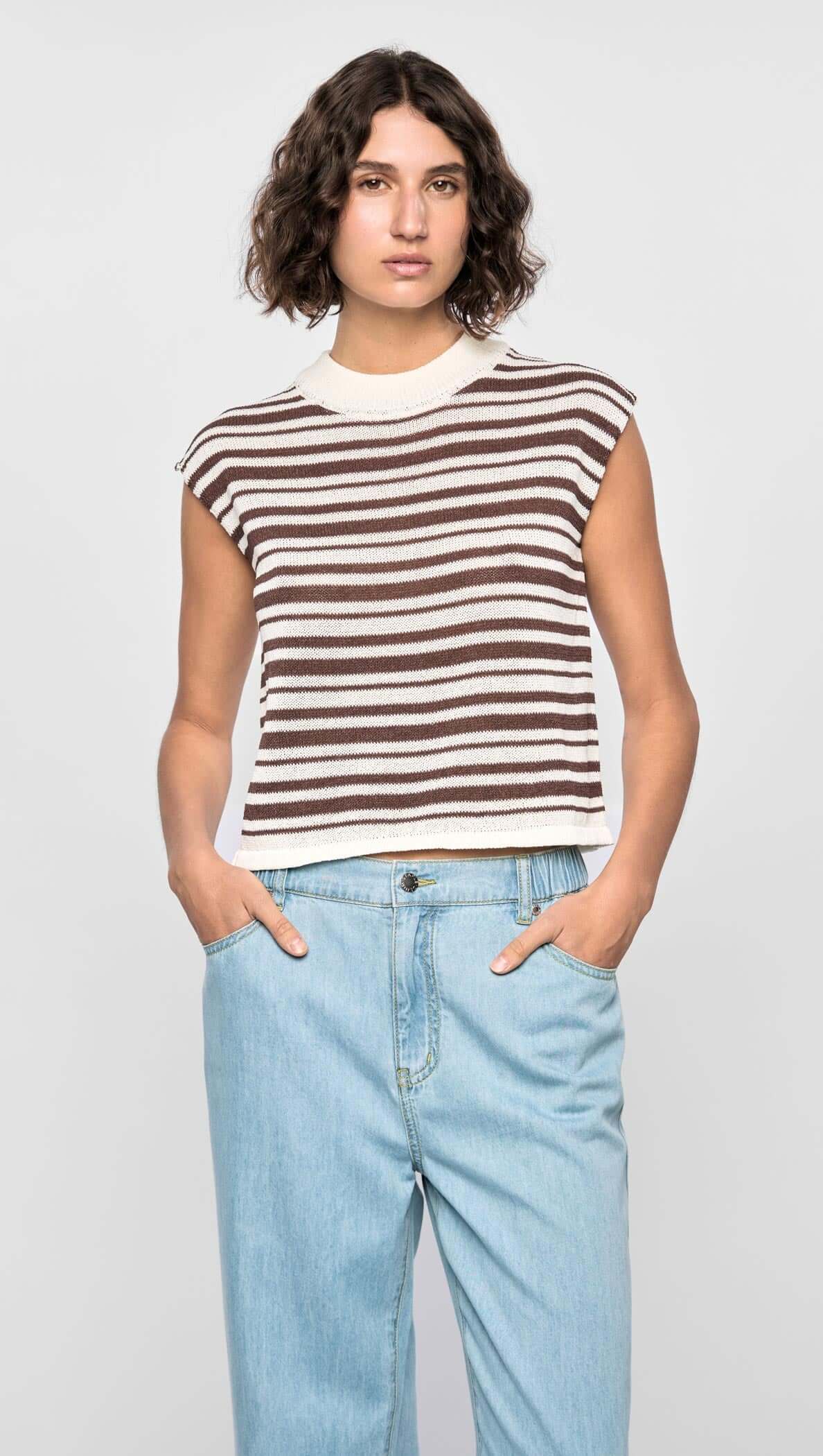 Model wearing the Palmer Stripe Knit Tank with cream and chocolate stripes, featuring a ribbed crew neckline and relaxed fit.