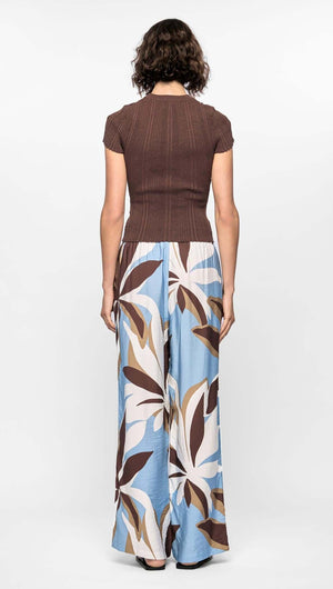 Back view of a model wearing Maeve Relaxed Pants with a brown top, featuring a wide-leg silhouette and abstract floral print.