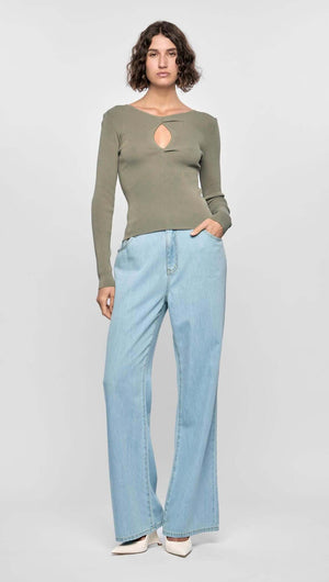 Model wearing the Mira Twist Knit Top in khaki with long sleeves and a twist front detail, paired with light blue flared jeans.