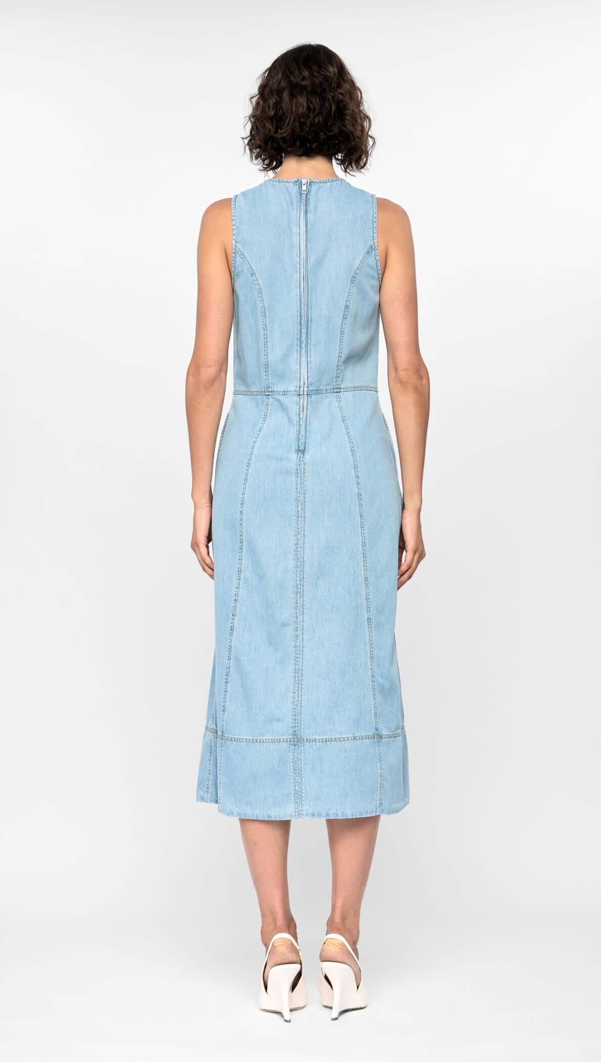 Back view of the Amelia Chambray Midi Dress in light blue, showcasing its fitted bodice, paneled design, and midi-length hem.