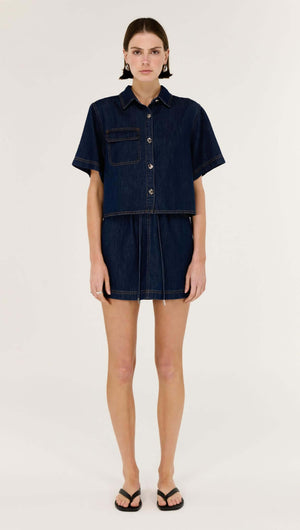 Denim Elasticated Mini Skirt worn by a model, showcasing structured indigo denim in a high-rise design.