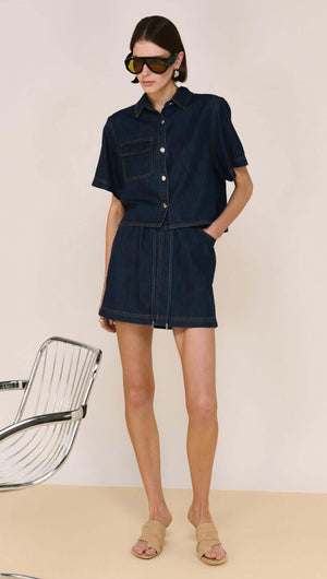 Model wearing a Denim Cropped Short-Sleeve Shirt with matching skirt, showcasing a stylish and modern denim look.