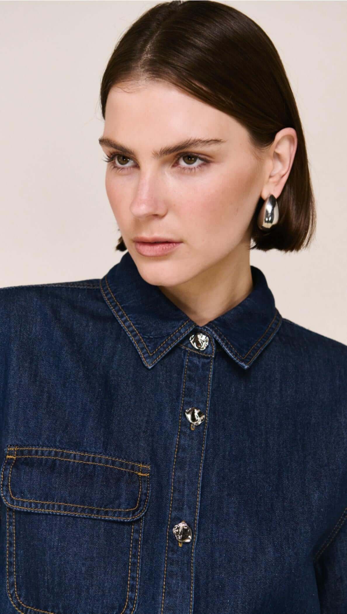 Denim Cropped Short-Sleeve Shirt featuring a structured cropped design and tailored lines, styled with a skirt.