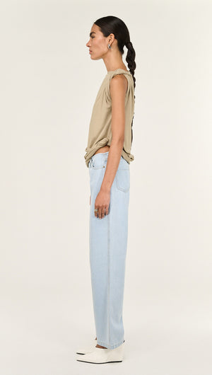 Model showcasing Light Wash Straight Leg Denim Jeans from the side, paired with a beige top and stylish shoes.