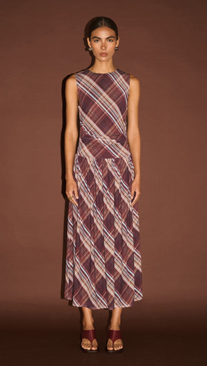 Plaid Mesh Midi Dress with Drop Waist worn by a model against a brown backdrop, showcasing a modern plaid pattern.