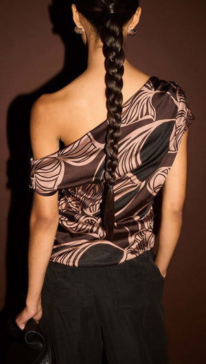 Model wearing an Abstract Leaf Print One Shoulder Top showing the back view with braided hair.
