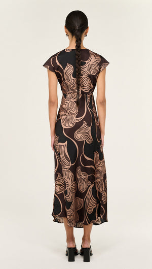 Back view of model wearing Abstract Leaf Print Bias Cut Midi Dress showcasing its elegant design and flowy silhouette.