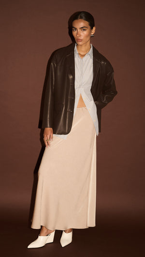 Model wearing a Champagne Bias Cut Satin Maxi Skirt paired with a stylish shirt and jacket.