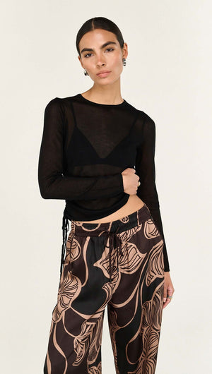 Model wearing Abstract Leaf Print Relaxed Silky Pants paired with a fitted black top, showcasing a chic outfit.