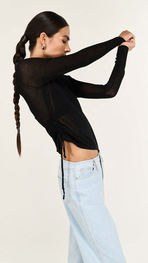 Model wearing Black Ruched Detail Sheer Knit Top with long sleeves and ruched detailing, paired with light blue jeans.