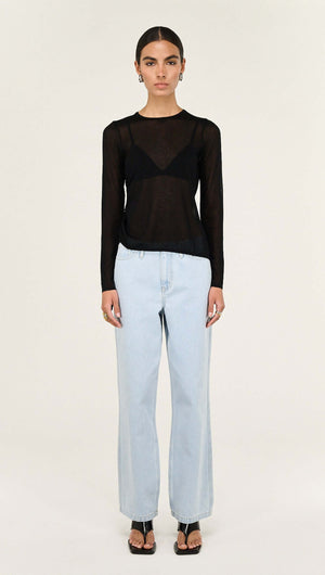 Model wearing a Black Ruched Detail Sheer Knit Top with light blue wide-leg jeans and strappy heels.