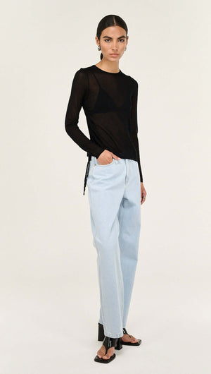 Model wearing a Black Ruched Detail Sheer Knit Top with light blue jeans and black sandals, showcasing contemporary style.