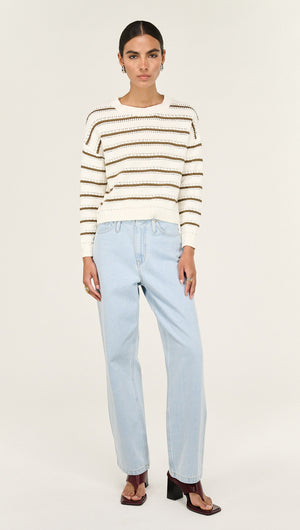 Woman wearing a Khaki Stripe Round Neck Jumper paired with light blue jeans, showcasing casual style and comfort.