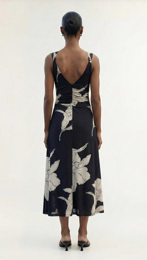 Back view of a model wearing a Sketched Floral Mesh Midi Dress in dark fabric with floral designs.
