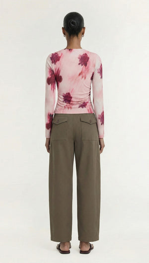 Rear view of a model wearing a Pink Floral Mesh Long Sleeve Top paired with wide-leg pants.