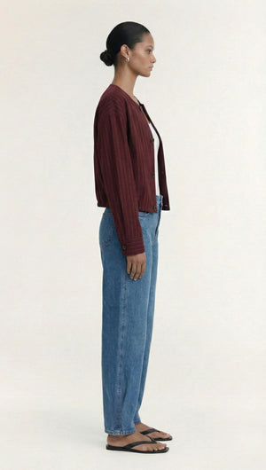 Burgundy Pinstripe Cropped Jacket displayed on a model from the side wearing denim jeans and sandals.