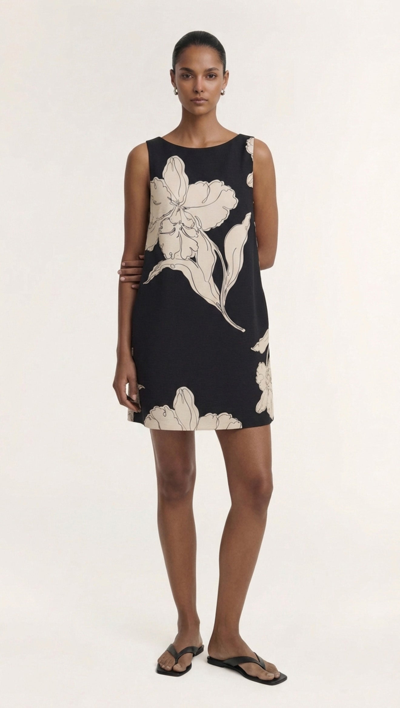 Sketched Floral Sleeveless Mini Dress featuring elegant floral patterns on a black background.
