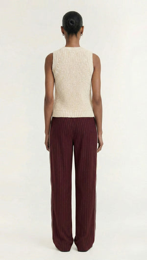 Model wearing a sleeveless top with Burgundy Pinstripe Relaxed Pant, showcasing the back view of the outfit.