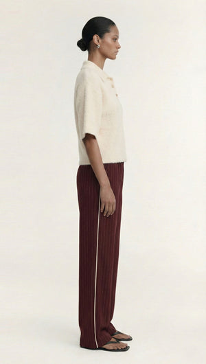 Model wearing a Fluffy Knit Polo Top in Cream with burgundy striped pants, showcasing a chic and elegant style.