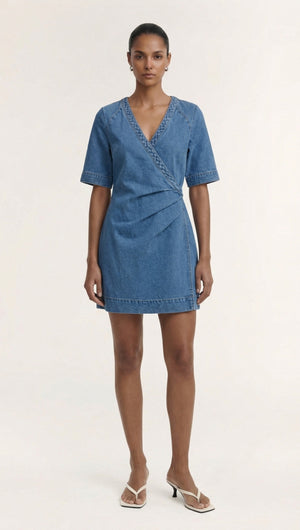 Model wearing a Cotton Denim Wrap Detail Mini Dress, showcasing its refined design and feminine silhouette with short sleeves.