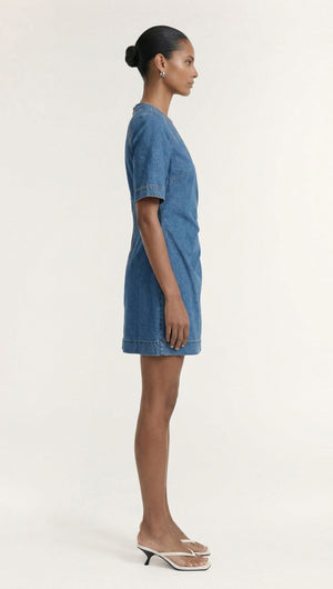 Model showcasing the Cotton Denim Wrap Detail Mini Dress in a side view, demonstrating its stylish, fitted design.