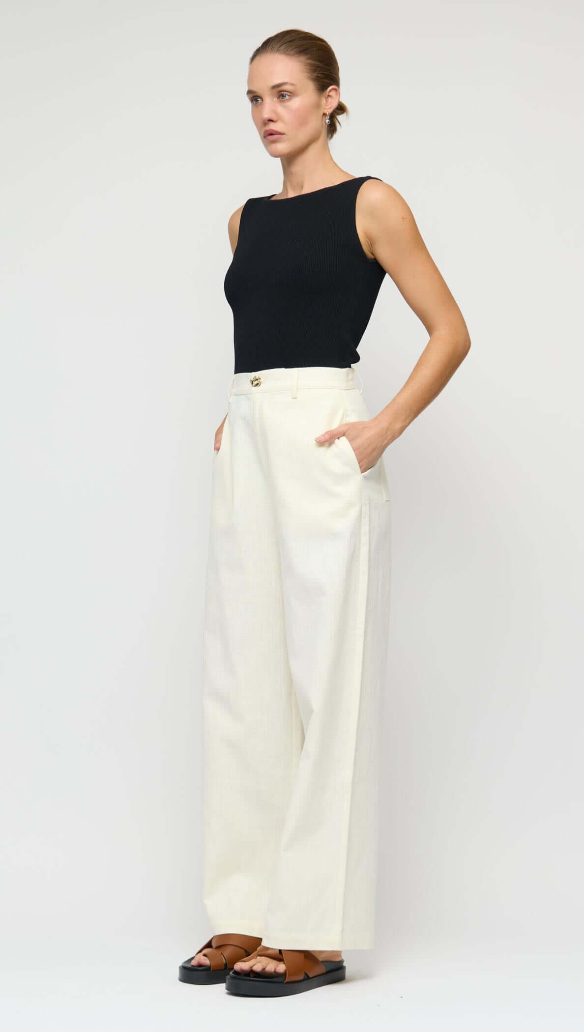 Model wearing Linen Blend White Wide-Leg Pants with a black top and straw bag.