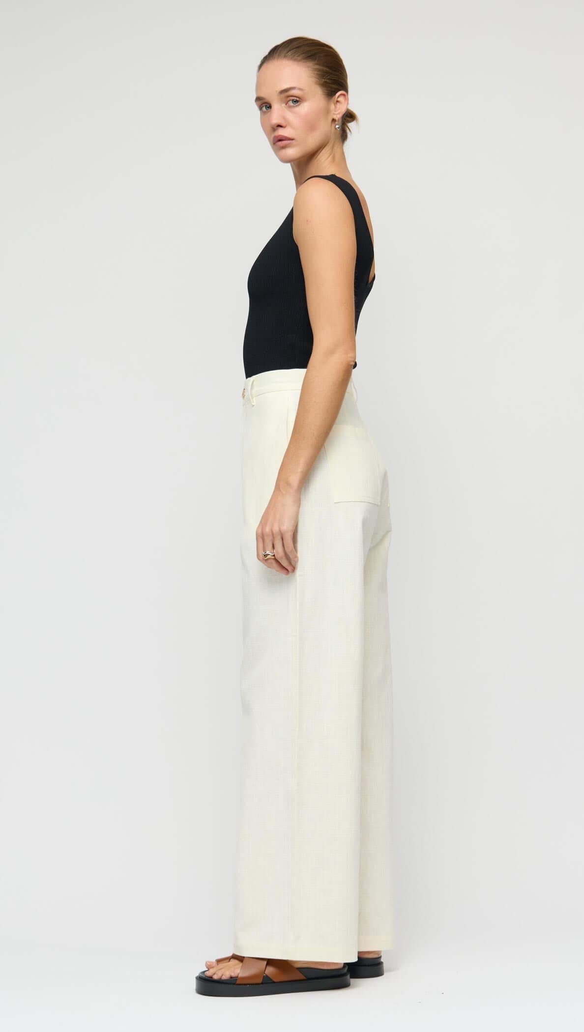 Model wearing Linen Blend White Wide-Leg Pants styled with a black top, showcasing its relaxed fit and high-rise silhouette.