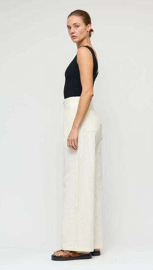 Model wearing Linen Blend White Wide-Leg Pants styled with a black top, showcasing its relaxed fit and high-rise silhouette.