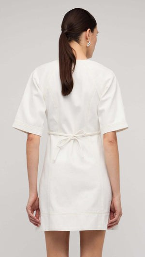 Back view of a white denim mini dress with short sleeves and a tie waist.