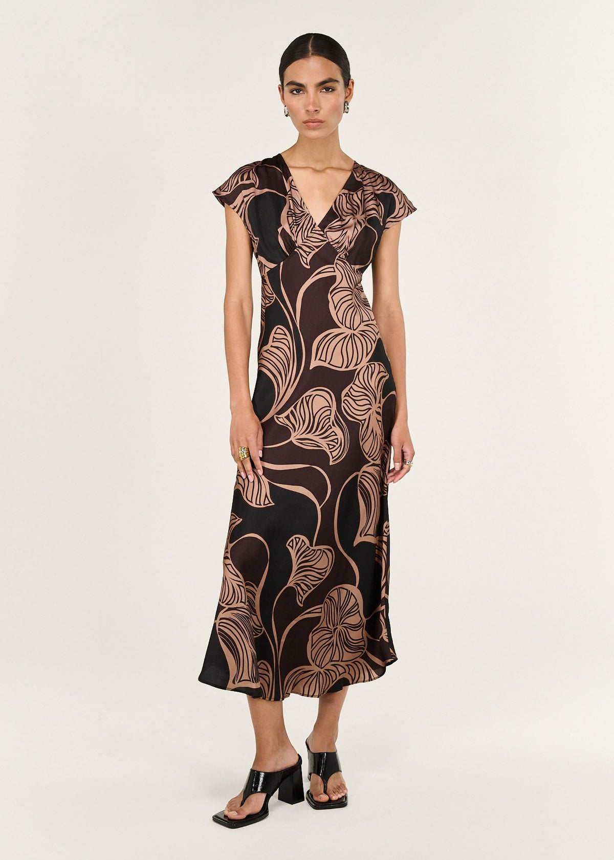 Model wearing Abstract Leaf Print Bias Cut Midi Dress with a soft V neckline and a cap sleeve detail.