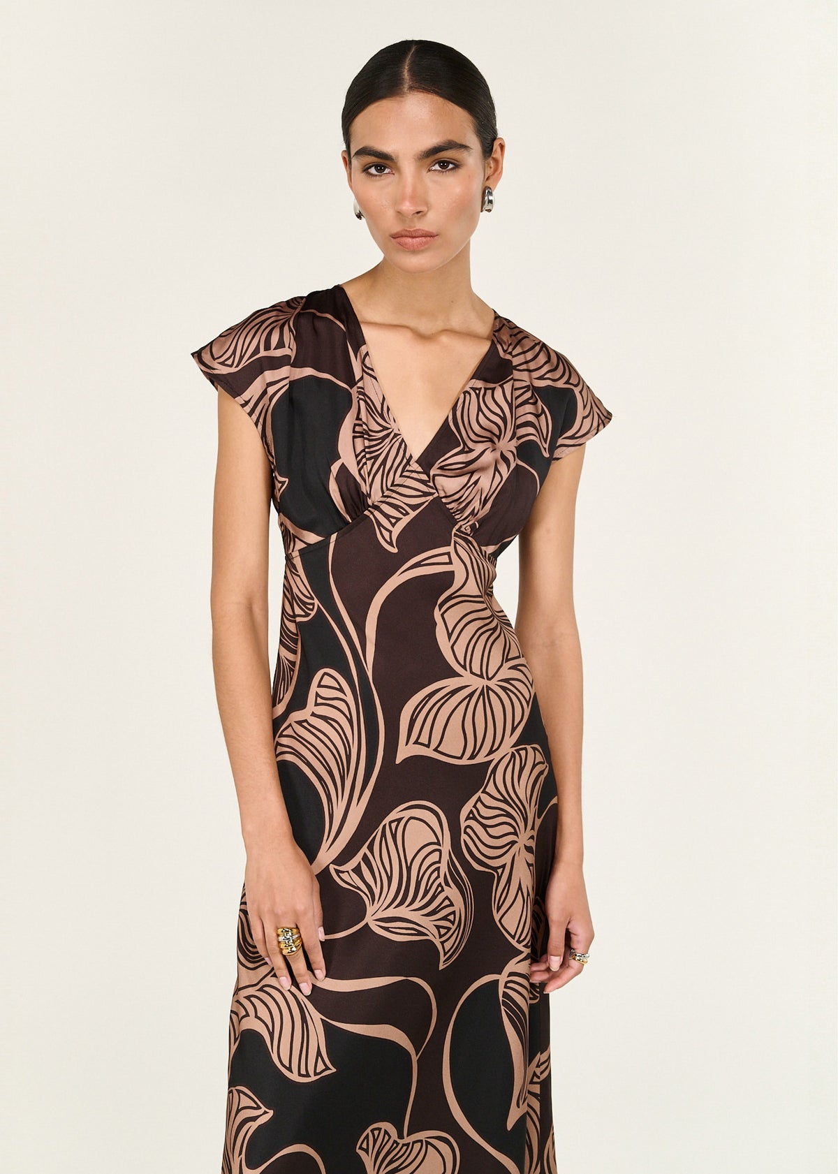 Model wearing Abstract Leaf Print Bias Cut Midi Dress with a fluid, body-skimming silhouette, turned to the side.