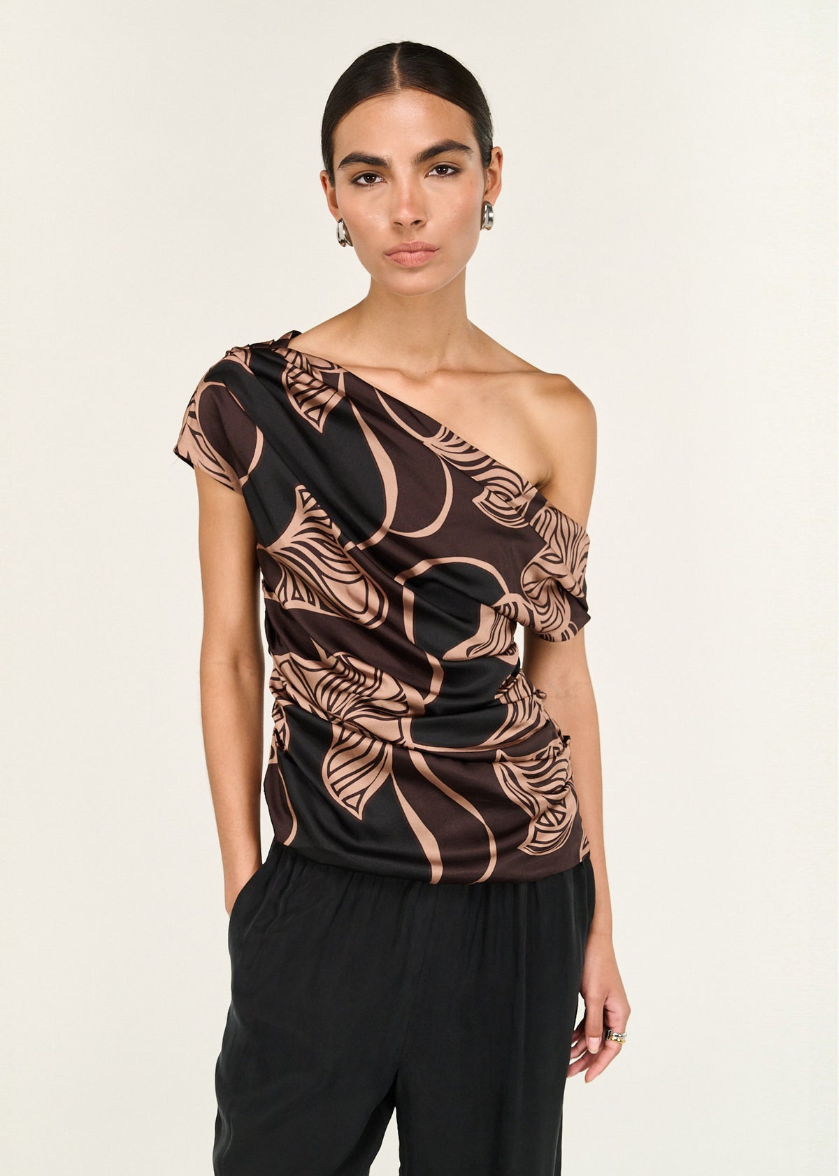 Model wearing Abstract Leaf Print One Shoulder Top with an asymmetric neckline with draped detail and a ruched body.