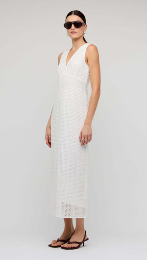White Broderie Bias Midi Dress worn by a model, showcasing sleeveless V-neck design and delicate broderie detailing.